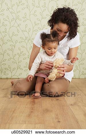 Mother holding baby girl on lap View Large Photo Image Stock Image - Mother holding baby girl on lap. Fotosearch