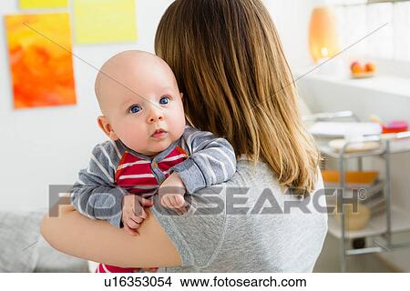 Mother holding baby son over shoulder View Large Photo Image Picture - Mother holding baby son over shoulder. Fotosearch