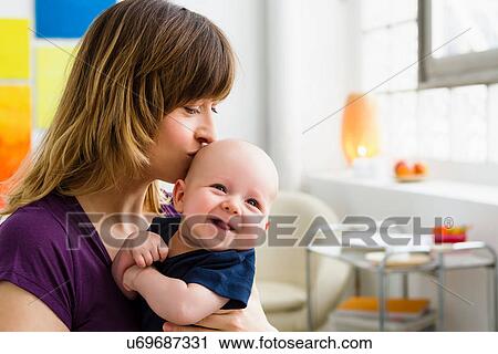 Mother kissing baby son on head View Large Photo Image Stock Image - Mother kissing baby son on head. Fotosearch