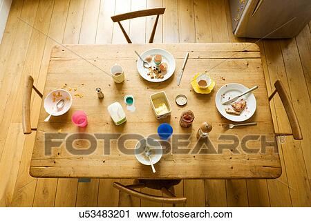 Stock Image - Overhead view of breakfast table with eaten food and messy plates. Fotosearch