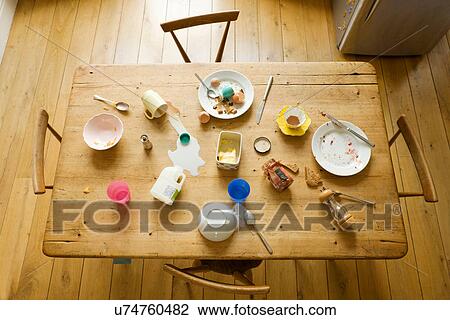 Stock Image - Overhead view of breakfast table with eaten food and messy plates. Fotosearch