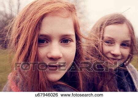 Stock Photograph - Portrait of girls wrapped in a blanket outdoors, smiling. Fotosearch