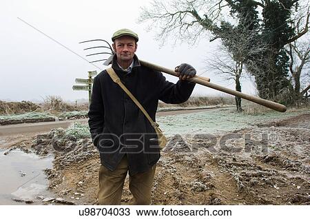 Portrait of mature farmer holding pitchfork View Large Photo Image Stock Image - Portrait of mature farmer holding pitchfork. Fotosearch