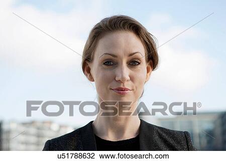 Stock Image - Portrait of mid adult woman, smiling. Fotosearch