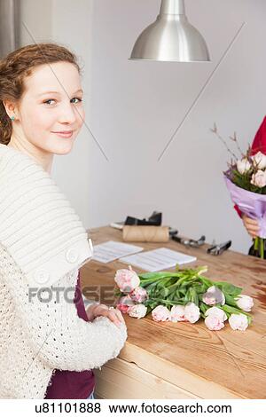 Stock Photo - Portrait of teenage girl buying roses in florists. Fotosearch