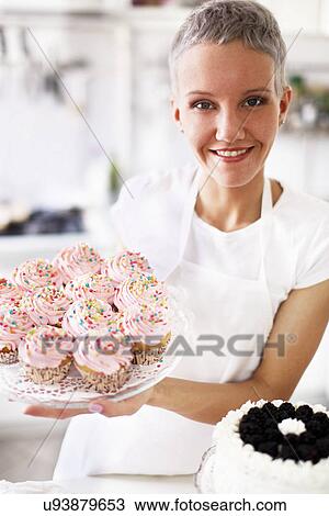 Portrait of woman holding hand made cupcakes View Large Photo Image Stock Image - Portrait of woman holding hand made cupcakes. Fotosearch