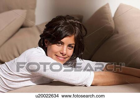Portrait of woman lying on sofa looking at camera View Large Photo Image Picture - Portrait of woman lying on sofa looking at camera. Fotosearch