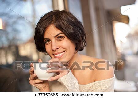 Stock Photography - Portrait of woman outside cafe drinking coffee. Fotosearch