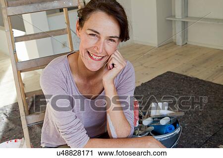 Stock Image - Portrait of woman wearing pink top, hand on chin. Fotosearch