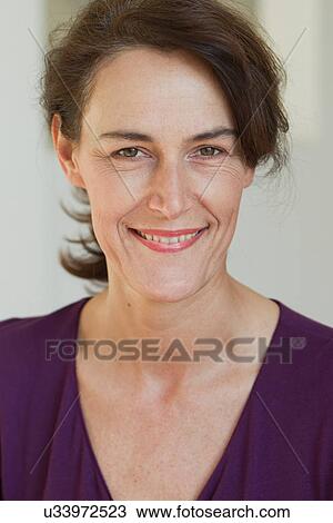 Stock Image - Portrait of woman wearing purple top. Fotosearch