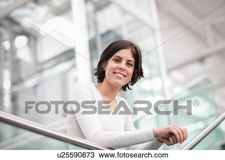 Portrait of young female leaning on handrail View Large Photo Image Stock Image - Portrait of young female leaning on handrail. Fotosearch
