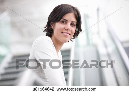 Stock Image - Portrait of young female on stairway. Fotosearch