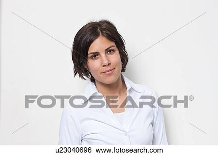 Stock Photograph - Portrait of young female wearing white in front of white background. Fotosearch
