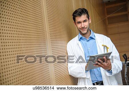 Portrait of young male doctor holding digital tablet View Large Photo Image Picture - Portrait of young male doctor holding digital tablet. Fotosearch