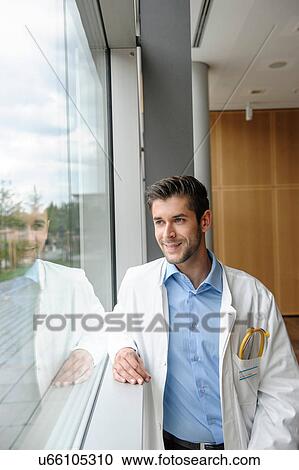 Stock Image - Portrait of young male doctor smiling. Fotosearch