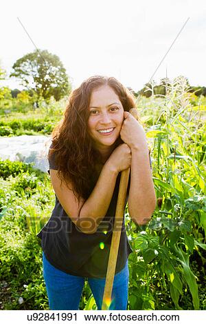 Portrait of young woman leaning on garden tool in allotment View Large Photo Image Stock Image - Portrait of young woman leaning on garden tool in allotment. Fotosearch