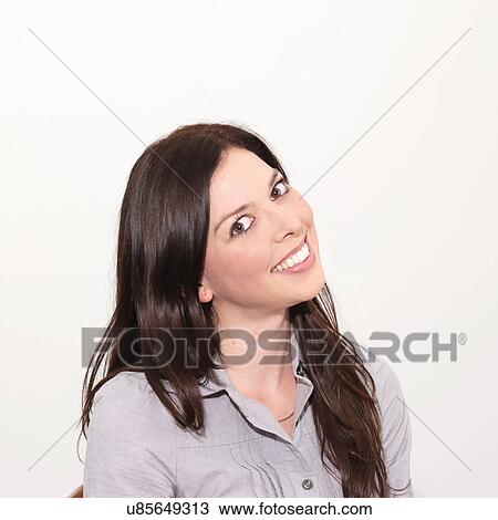 Portrait of young woman smiling against white background View Large Photo Image Stock Image - Portrait of young woman smiling against white background. Fotosearch