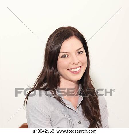 Portrait of young woman smiling against white background View Large Photo Image Stock Photo - Portrait of young woman smiling against white background. Fotosearch
