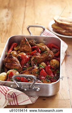 Picture - Roast chicken and vegetables in roasting tin. Fotosearch