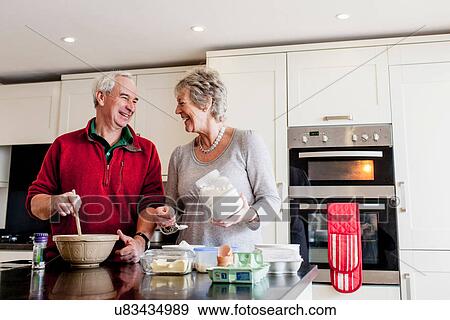 Stock Photo - Senior couple baking together in kitchen. Fotosearch