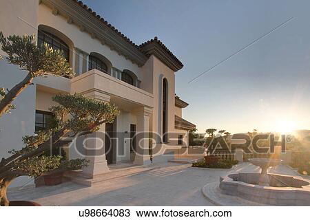 Stock Image - Sunlight on exterior of luxury villa. Fotosearch