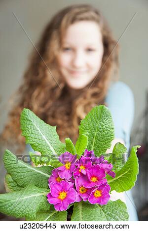 Stock Photography - Teenage girl holding flowers, close up. Fotosearch