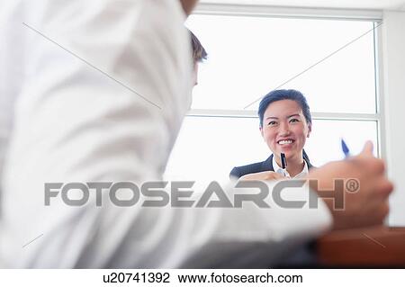 Stock Image - Three business colleagues in office meeting. Fotosearch