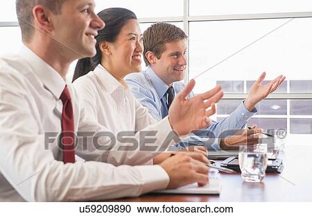 Stock Image - Three business colleagues in office meeting. Fotosearch