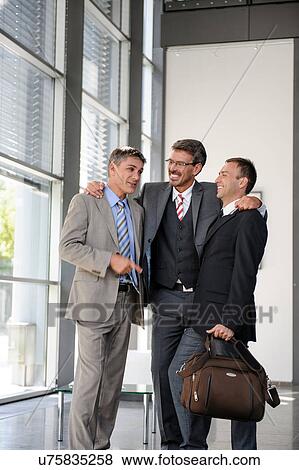 Three businessmen talking and laughing View Large Photo Image Stock Photo - Three businessmen talking and laughing. Fotosearch