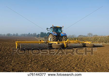 Stock Photo - Tractor preparing the ground of field. Fotosearch
