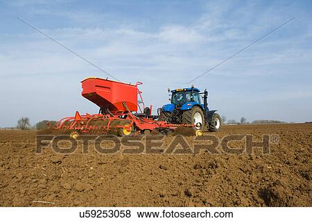 Tractor pulling equipment to plant seeds in field View Large Photo Image Stock Photo - Tractor pulling equipment to plant seeds in field. Fotosearch