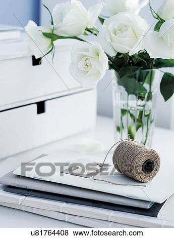 Stock Photo - White roses in vase with ball of string, still life. Fotosearch
