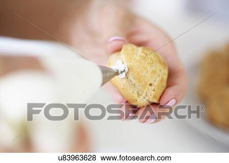 Woman filling profiterole with cream View Large Photo Image Stock Photo - Woman filling profiterole with cream. Fotosearch