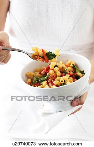 Woman holding bowl of cellantani pasta View Large Photo Image Stock Image - Woman holding bowl of cellantani pasta. Fotosearch