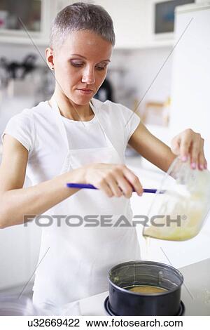 Woman pouring cake mixture into cake tin View Large Photo Image Stock Image - Woman pouring cake mixture into cake tin. Fotosearch