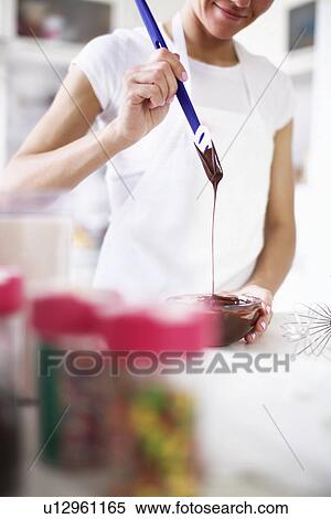 Woman pouring melted chocolate View Large Photo Image Stock Photography - Woman pouring melted chocolate. Fotosearch