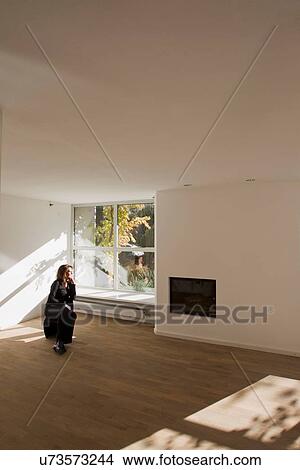 Woman sitting on chair in empty room View Large Photo Image Picture - Woman sitting on chair in empty room. Fotosearch