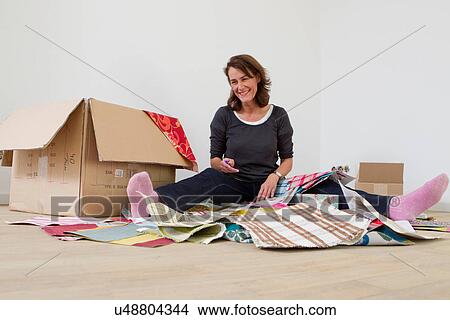 Woman sitting on floor with box of fabric samples View Large Photo Image Picture - Woman sitting on floor with box of fabric samples. Fotosearch