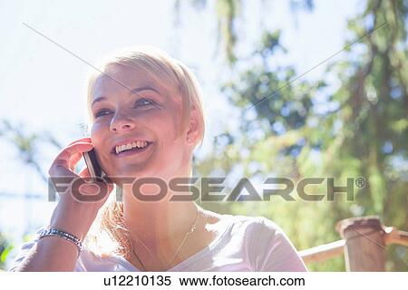 Woman using cell phone in garden View Large Photo Image Stock Photography - Woman using cell phone in garden. Fotosearch