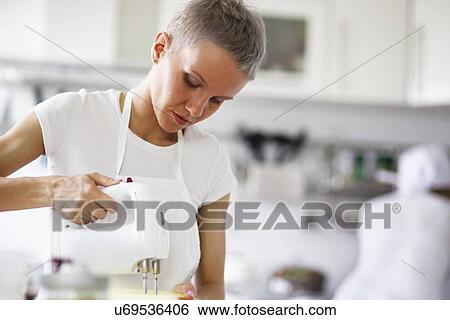Stock Photograph - Woman using electric whisk. Fotosearch