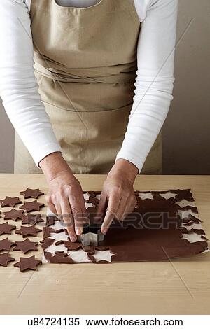 Woman using star shaped pastry cutter to cut chocolate View Large Photo Image Stock Photography - Woman using star shaped pastry cutter to cut chocolate. Fotosearch