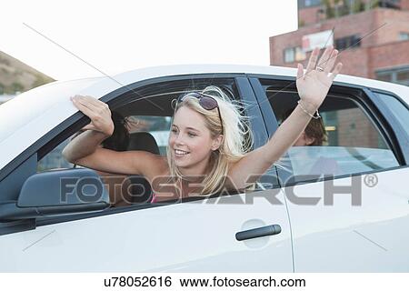 Stock Photograph - Woman waving through car window. Fotosearch