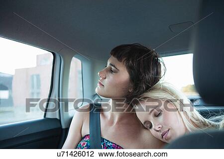 Women in backseat of car, one with head on friend's shoulder View Large Photo Image Stock Image - Women in backseat of car, one with head on friend's shoulder. Fotosearch