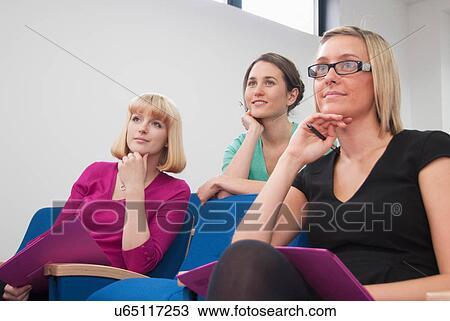 Stock Image - Women listening to presentation. Fotosearch