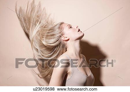 Stock Photo - Young blonde woman flicking hair. Fotosearch