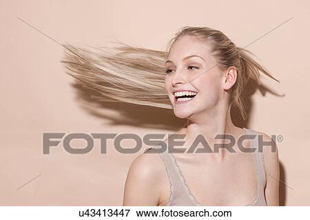 Stock Photo - Young blonde woman flicking hair. Fotosearch