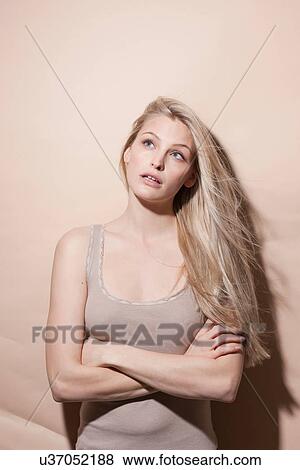 Young blonde woman looking up with arms crossed View Large Photo Image Stock Photo - Young blonde woman looking up with arms crossed. Fotosearch