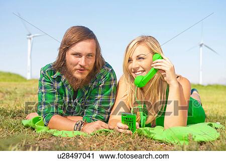 Young couple lying in field, woman on green cell phone View Large Photo Image Stock Image - Young couple lying in field, woman on green cell phone. Fotosearch