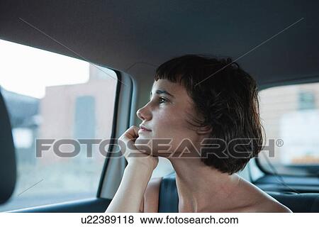 Young woman looking out of car window View Large Photo Image Stock Photo - Young woman looking out of car window. Fotosearch