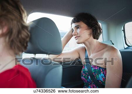 Stock Photograph - Young woman looking out of car window. Fotosearch